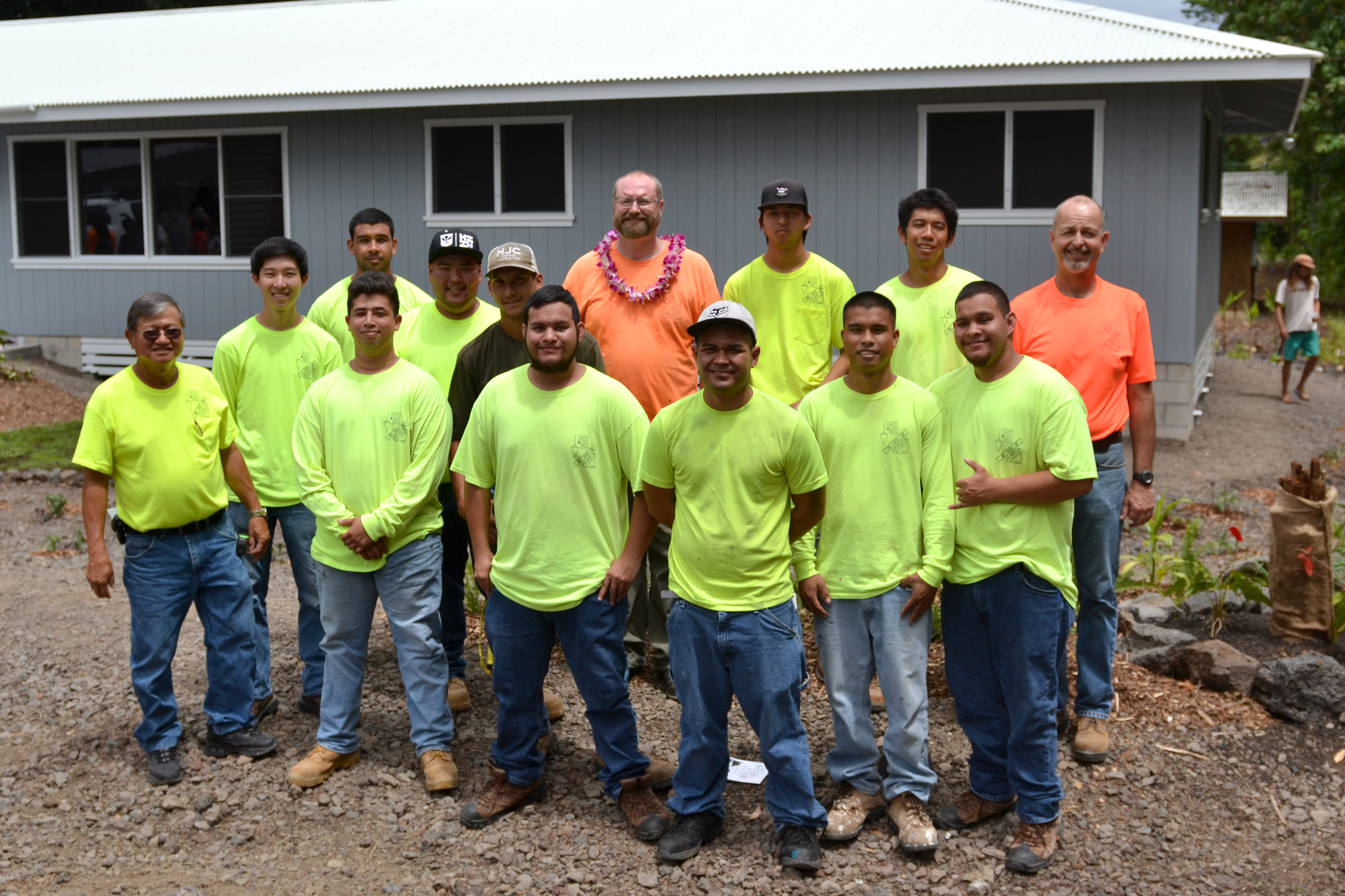 Group photo of carpentry students outside house they built