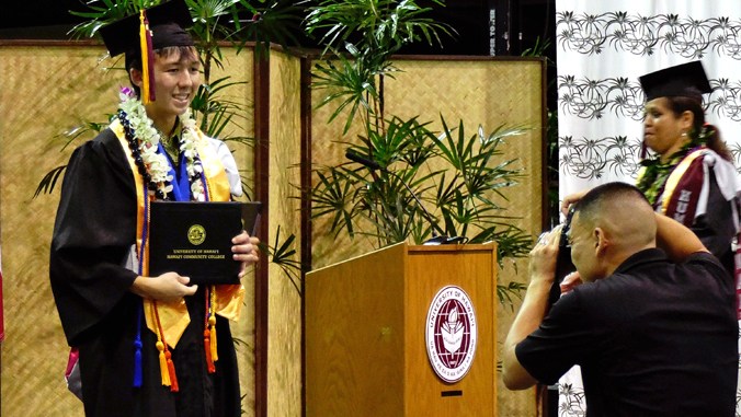 Craig Okahara-Olsen with his degree at commencement
