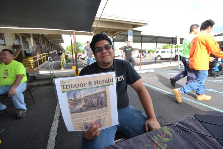 Joshua Doctor posing with newspaper