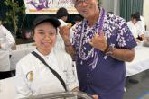  Hawai'i CC Culinary Program student Keala Banashian offers event emcee Dwayne Mukai a liliko'i tart.