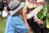 Camacho, covered in lei to the top of his head, is greeted by his grandmother after the ceremony.